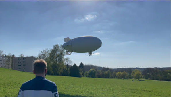 The airship flying over the test field, watched from the ground